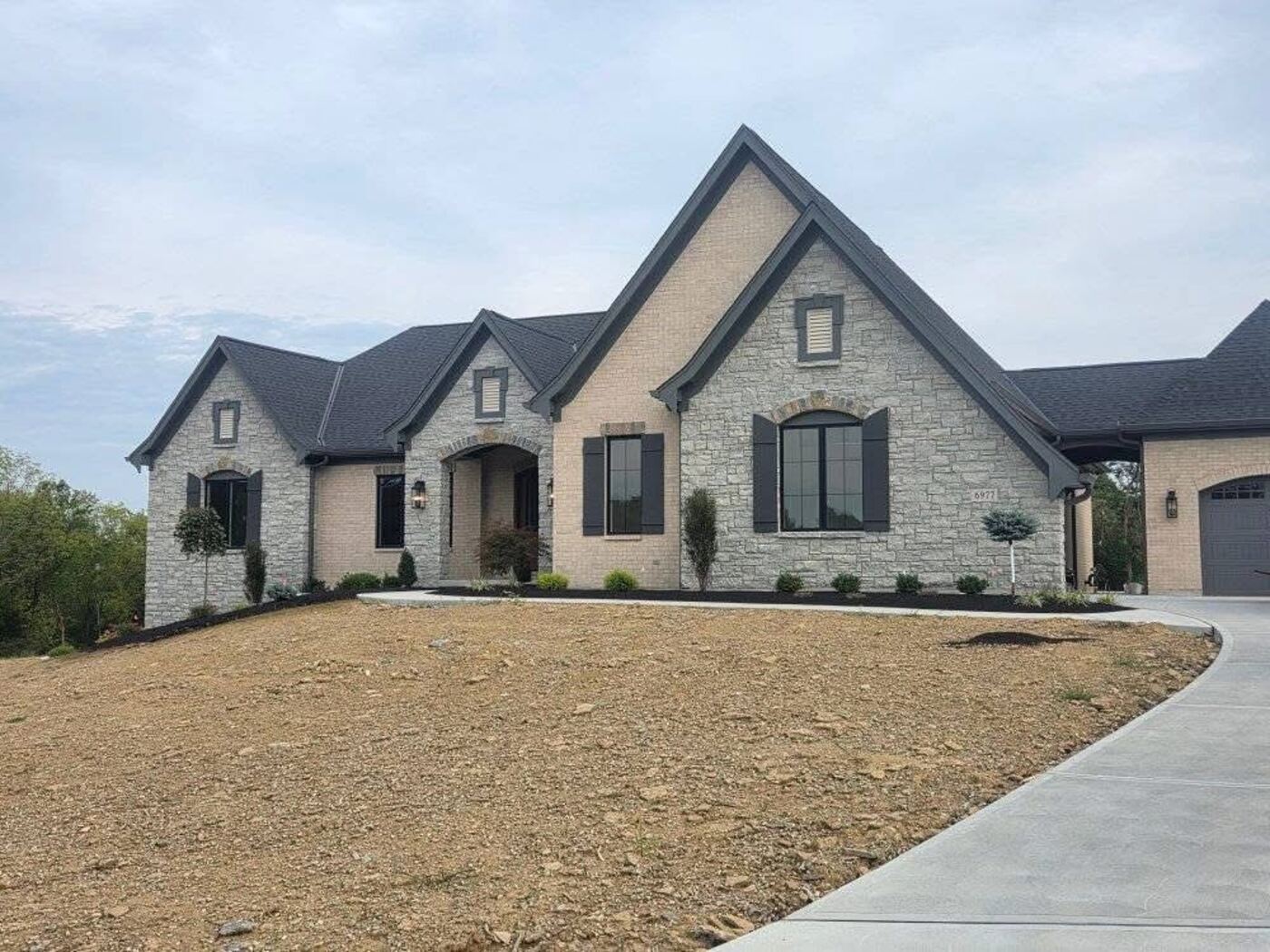 Custom craftsman-style home with stone wainscoting and stone porch columns
